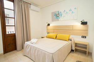 1 dormitorio con 1 cama con almohadas amarillas en Hotel La Perdi, en Sant Mateu