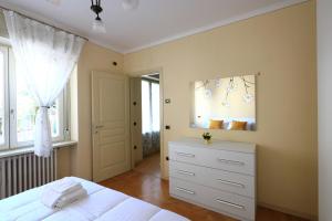 - une chambre avec un lit blanc et un miroir dans l'établissement DA MEGGY, à Stresa