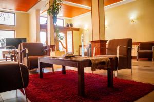 una sala de espera con mesa y sillas en Hotel Villa Brescia en Ushuaia