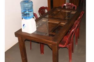un tavolo in legno con una bottiglia d'acqua in cima di Leaf Dew Resort a Anuradhapura