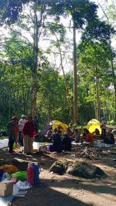 grupa ludzi siedzących na ziemi z namiotami w obiekcie Joben Evergreen Camp w mieście Tetebatu