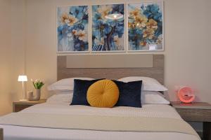 a bedroom with a bed with a yellow pillow on it at Zeta - Garden Oasis & Private Parking in Katerini