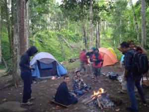 a group of people standing around a camp fire at Joben Evergreen Camp in Tetebatu