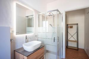 a white bathroom with a sink and a shower at Bologna41 in Parma