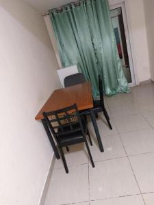 einen Tisch und Stühle in einem Zimmer mit Fenster in der Unterkunft TWO BEDROOM VACATION HOME AT SHARJAH DUBAI BOARDER BY MAUON.COM in Schardscha