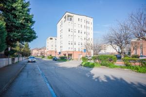 an empty street with a tall white building at Bologna41 in Parma