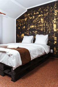 a bedroom with a large bed with a black and gold wall at Casa Rosu in Cluj-Napoca