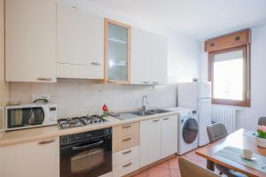 a kitchen with white cabinets and a stove top oven at Bologna41 in Parma +11 photos