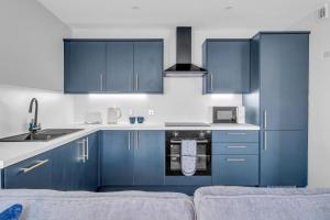 una cocina con armarios azules y fregadero en King Street Stay - SJA Stays - Luxury 2 Bed Apartment en Aberdeen