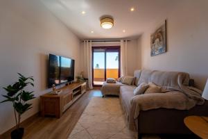a living room with a couch and a flat screen tv at Cala Azul Unique in La Cala de Mijas
