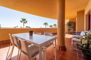 a dining room with a white table and chairs at Cala Azul Unique in La Cala de Mijas