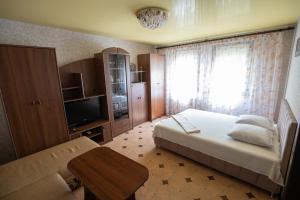 a bedroom with a bed and a tv and a couch at Героїв Дніпра, 53, 3-й поверх, квартира біля пляжу Живчик in Cherkasy