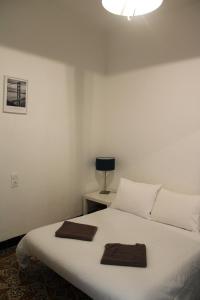 1 dormitorio con 1 cama blanca y 2 toallas en Superbe appartement avec parking sur place, en Nimes