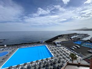 - une vue sur la piscine avec des chaises et l'océan dans l'établissement Mirador La Galera, junto a la playa, à Candelaria