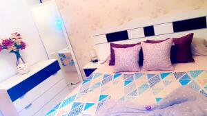 sypialnia z łóżkiem z fioletowymi i różowymi poduszkami w obiekcie HABITACIÓN & Confort JP w mieście Aguadulce