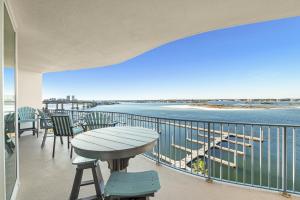 balcón con mesa, sillas y vistas al océano en Caribe Resort Unit B603, en Orange Beach