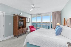 a bedroom with a bed and a tv and a window at Caribe Resort Unit B603 in Orange Beach