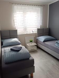 a bedroom with two beds and a window at Apartament Zielony Zakątek Wrocław in Wrocław