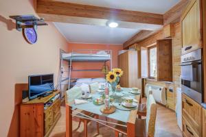 a small room with a table and a bunk bed at Studio Borgata Ski In Ski Out 300m - Happy Rentals in Sestriere