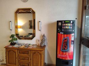 una habitación con una máquina de refrescos junto a un tocador en HOTEL Schiff, en Rastatt