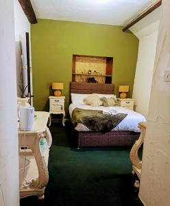 a bedroom with a bed and a green wall at The Bay Horse Hotel Wolsingham in Wolsingham