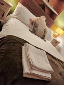 Una cama con mantas blancas y almohadas. en The Bay Horse Hotel Wolsingham, en Wolsingham