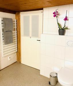 a bathroom with a toilet and a window and a flower at Lovely & great equipped wooden Alp Chalet flat in Kandersteg