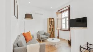 uma sala de estar com um sofá e uma cadeira e uma televisão em Sintra Retreat Residences 3 by LovelyStay em Sintra