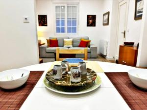 una sala de estar con una mesa con tazas. en Holibai, Viaxeiro, Apto tranquilo y moderno, en Baiona