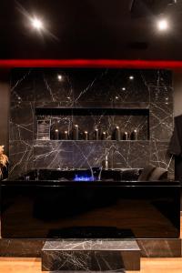 a bathroom with a black marble wall with a tub at BlackRoom Suite de Luxe 50 Nuances de grey in Le Havre