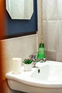 a bathroom sink with a green bottle on it at Casa Rosu in Cluj-Napoca