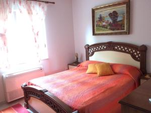 a bedroom with a wooden bed with a yellow pillow on it at Apartment Eurocoli Rezidence in Golem