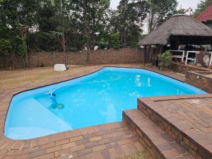 a large blue swimming pool with a gazebo at Downham Views in Johannesburg