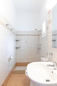 a white bathroom with a sink and a toilet at Porto Kassiopi Apartments in Kassiopi