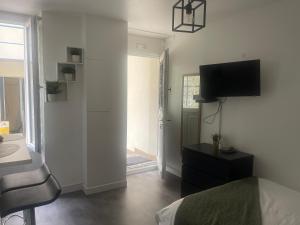 een slaapkamer met een bed en een televisie aan de muur bij Eiffel Tour Cosy Oliver in Parijs