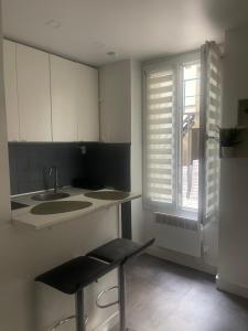 a white kitchen with a sink and a window at Eiffel Tour Cosy Oliver in Paris