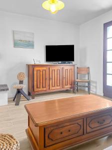 a living room with a tv and a wooden entertainment center at Havre de Lumière à La Barre-de-Monts in La Barre-de-Monts +13 photos
