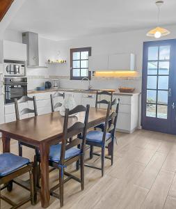 a kitchen with a wooden table and chairs at Havre de Lumière à La Barre-de-Monts in La Barre-de-Monts