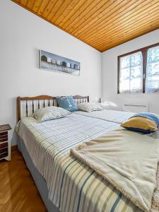 1 cama grande en un dormitorio con techo de madera en Plage et Forêt à La Barre-de-Monts, en La Barre-de-Monts