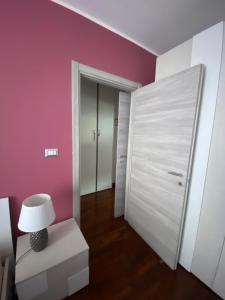 Habitación con paredes rosas y puerta blanca. en Inalpi Arena stadio olimpico private parking 15 minuti dal centro, en Turín