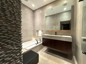 a bathroom with a sink and a tub and a mirror at Hyde Park Central South Kensington in London