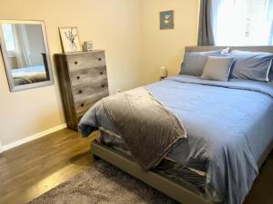a bedroom with a bed and a dresser and a mirror at Queen Suite - Hot Tub - Wifi Room 2 in Forest Park