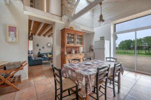 cocina y comedor con mesa y sillas en Gîte les Arcades 25 couchages, en Saint-Gildas-des-Bois