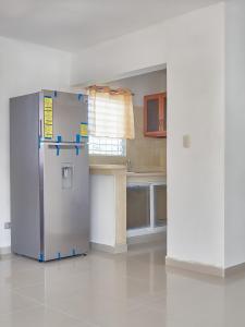 a kitchen with a stainless steel refrigerator in a room at Lovely and peaceful stay in San Pedro de Macorís