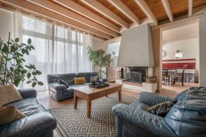 sala de estar con sofás, mesa y chimenea en Gîte les Arcades 25 couchages, en Saint-Gildas-des-Bois