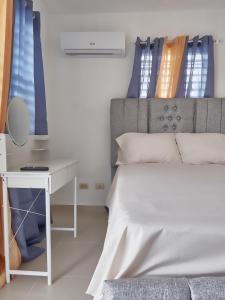 a bedroom with a bed and a desk with a mirror at Lovely and peaceful stay in San Pedro de Macorís