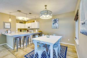 a kitchen with a white table and bar with stools at Panama City Beach Home Steps to the Ocean! in Panama City Beach