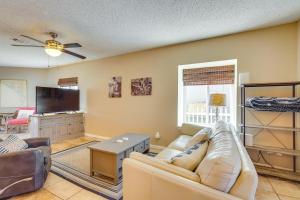 a living room with a couch and a flat screen tv at Panama City Beach Home Steps to the Ocean! in Panama City Beach