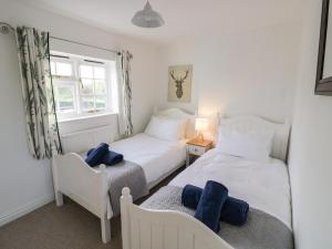 1 dormitorio con 2 camas y ventana en Home Farm Cottage, en Southam