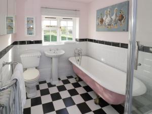 a bathroom with a tub and a toilet and a sink at Home Farm Cottage in Southam
